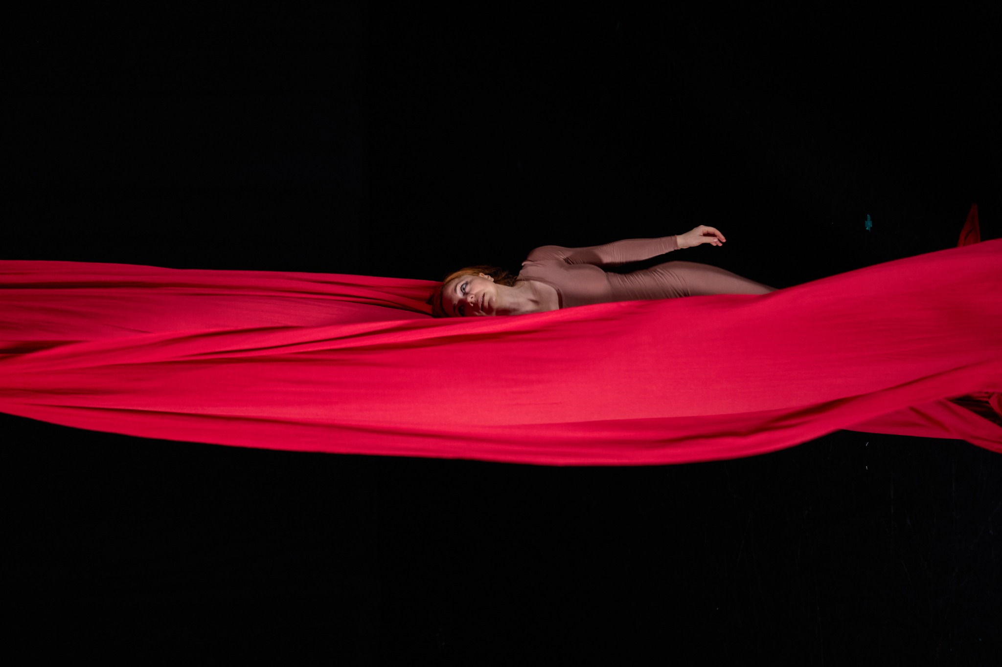 The body held between horizontal layers of red fabric