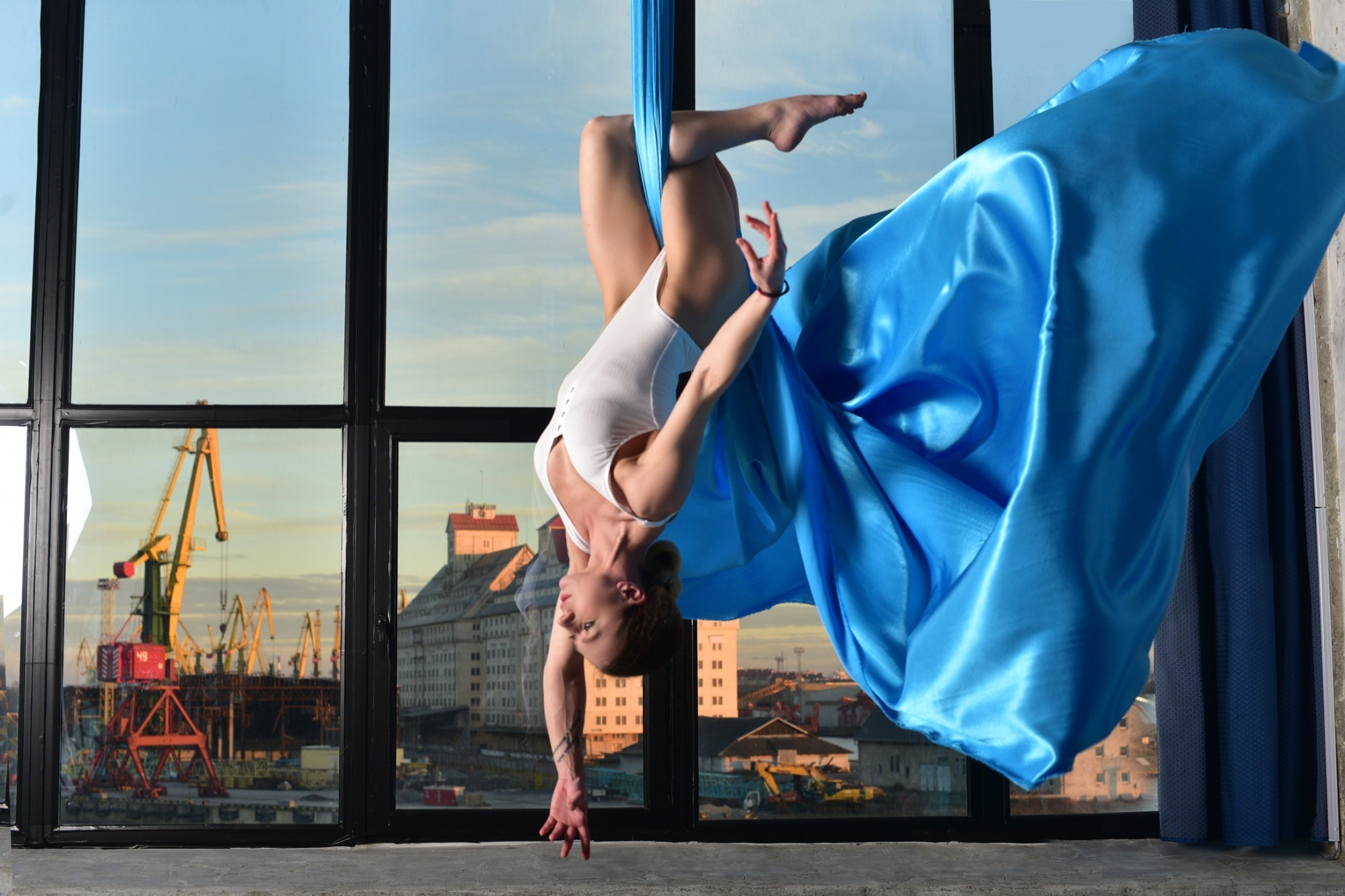 Body suspended beside a large field of blue fabric