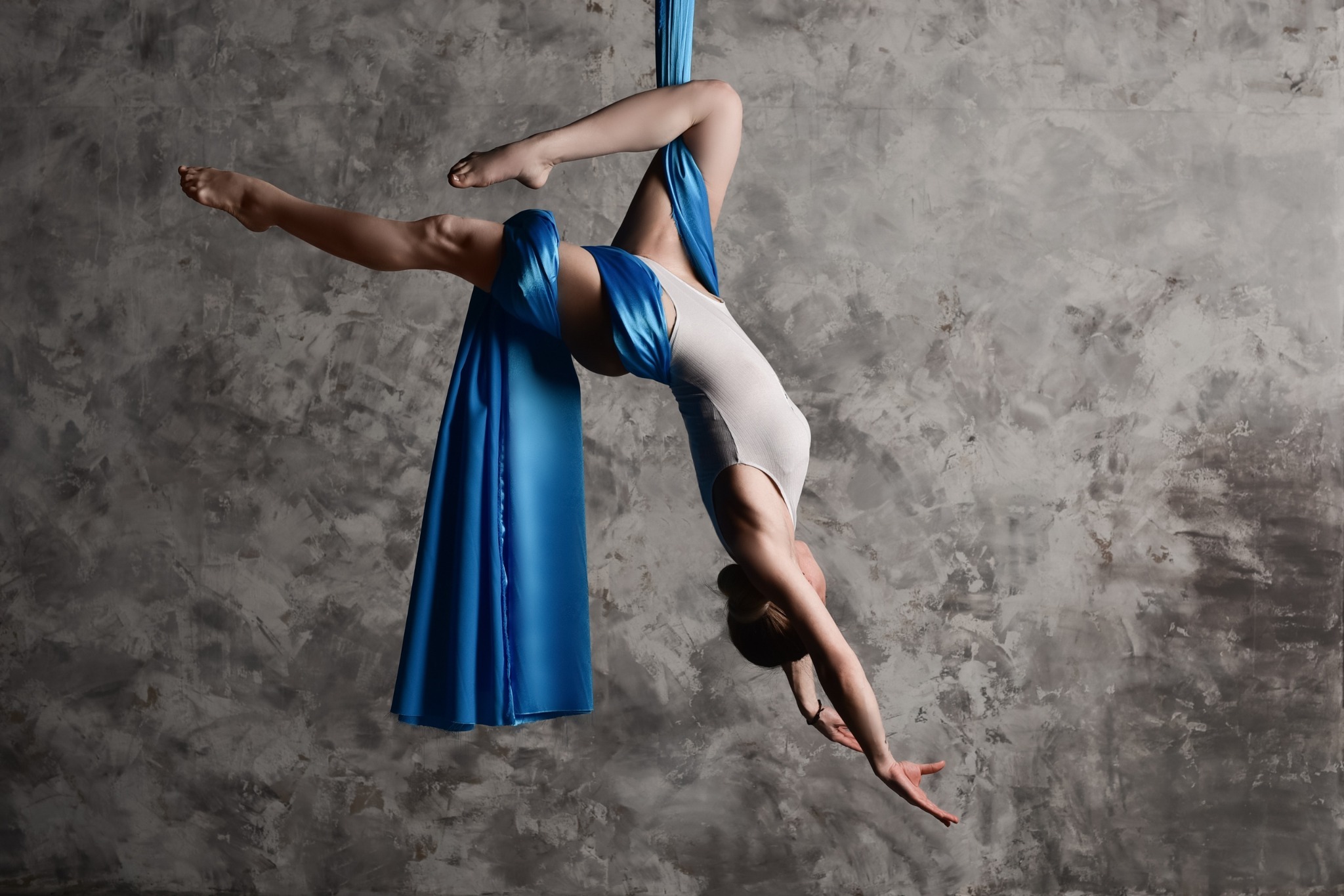 Body folded through blue aerial fabric