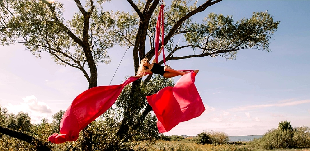 Body and red aerial fabric suspended from a tree