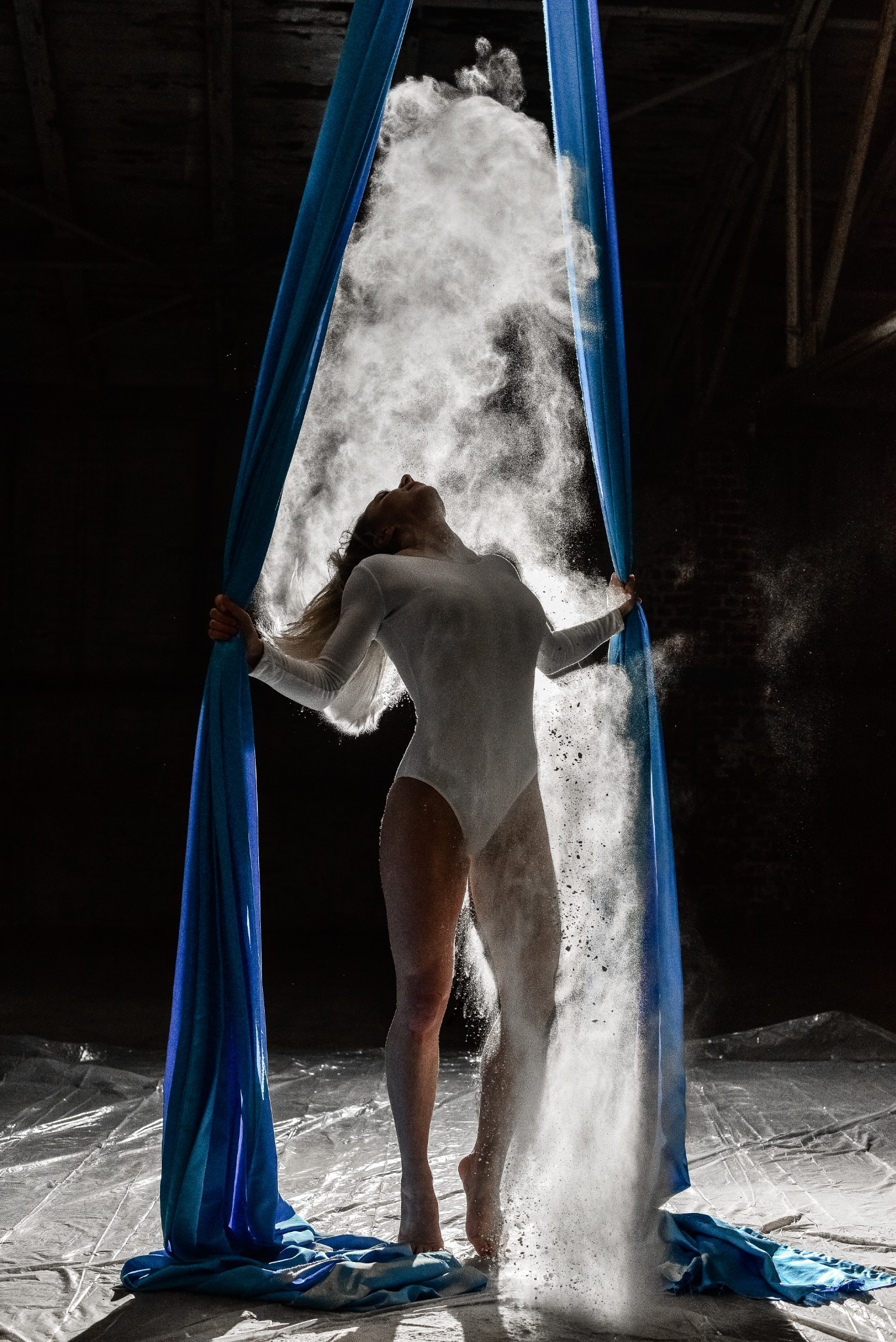Flour cloud forming around a body and blue fabric